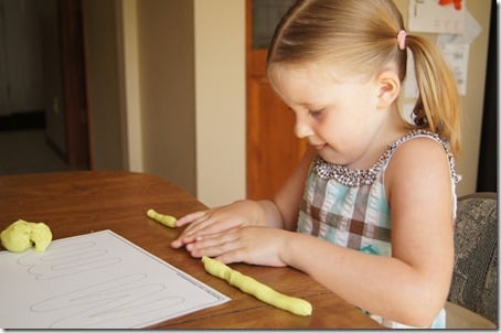 Preschooler using playdough mats